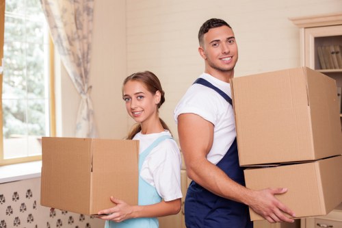 Local movers carrying items from a Roehampton property with limited access